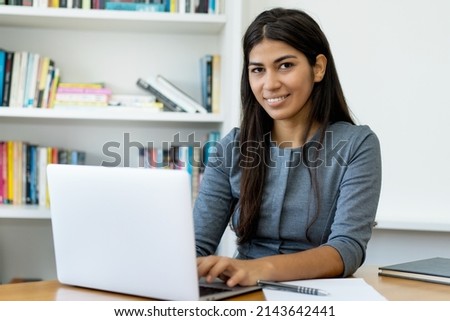Native south american woman working at computer at office Royalty-Free Stock Photo #2143642441
