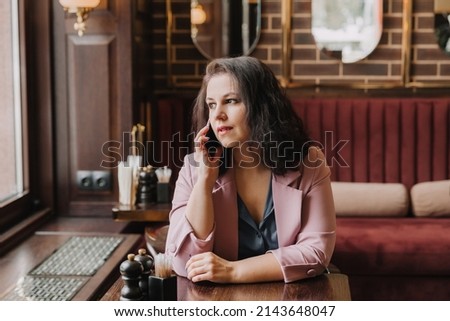 confident young woman holding a smartphone, talking, calling on the phone, business woman consulting a client