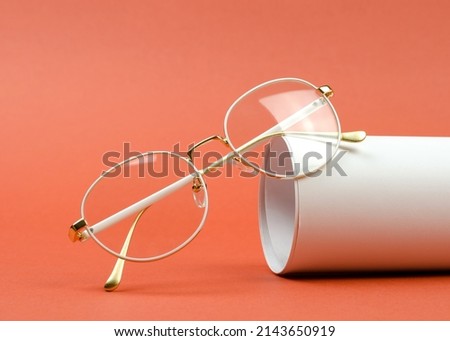 Stylish women's eyeglasses in a white frame on an orange background Royalty-Free Stock Photo #2143650919
