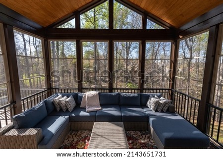 Screened porch in springtime, full of blooms trees in the background. New home addition concept.