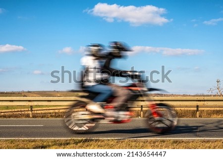 Motorcyclist and pillion on a motorcycle with blue sky on the theme of transportation and freedom Royalty-Free Stock Photo #2143654447