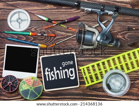 fishing tackle and photoframe on wooden table