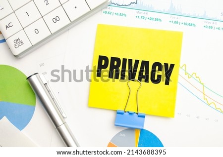 PRIVACY text on the white paper on the light background with charts paper