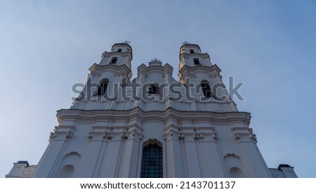 Catholic cathedral in Baroque style against the sky. An old tall building with two towers. Heritage and worship concepts.