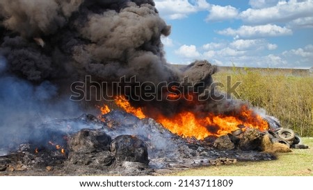 Burning landscape. Vehicle tires and haystacks on fire, black smoke invading the landscape...demonstrations against the environment Royalty-Free Stock Photo #2143711809