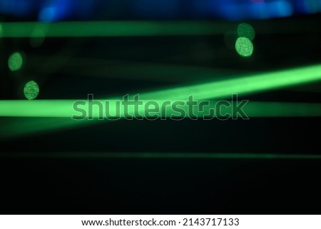 Bright green neon laser lights illuminate the darkness creating lines.