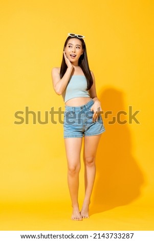 Summer portrait of Asian woman in isolated yellow studio background