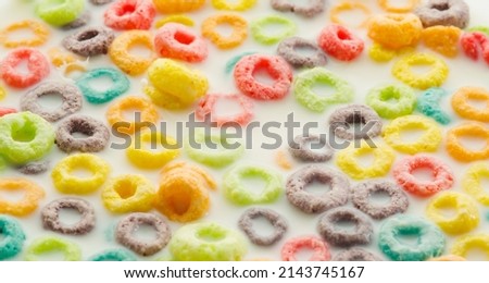 Quick whole grain breakfast. Multi-colored fruit rings in milk. Close-up. Lots of objects. Fast food, children's, school food. Vitamins, healthy lifestyle, diet food. Close-up. Banner.