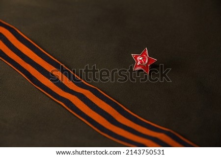 Soviet red star badge on the background of the St. George ribbon and army fabric.