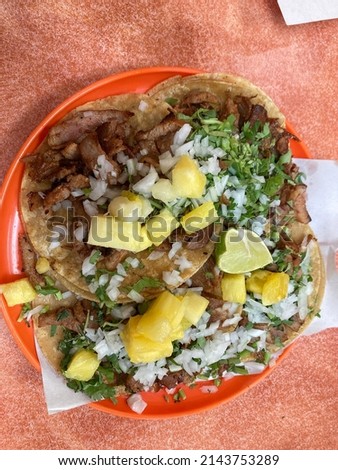 Mexican Tacos al pastor with cilantro, onion, pineapple, ready to eat