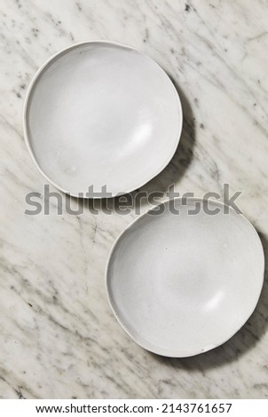 Still life photography of a white stoneware bowls on a marble background for food photography. Top view mock up.