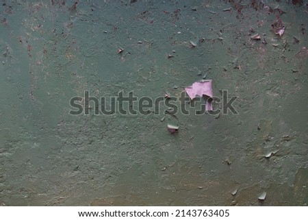 The background of the old painted wall is green with peeling paint.