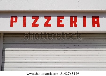 Pizza pizzeria restaurant red sign old vintage on street outside view of rustic text on wall facade 