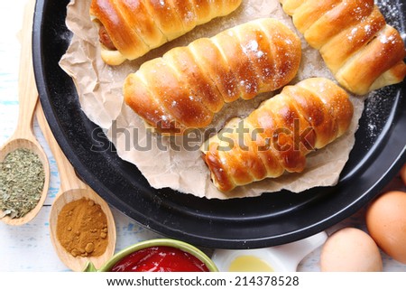 Baked sausage rolls in pan on table close-up