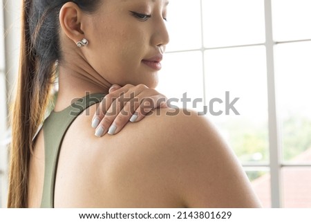 Tired sport asian woman massaging rubbing stiff sore neck tensed muscles fatigued from computer work in incorrect posture feeling hurt joint shoulder back pain ache, fibromyalgia concept, close up.