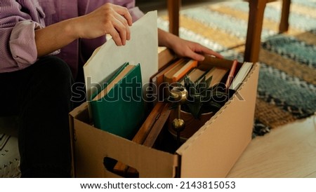 Beautiful Caucasian Female Hands Unpacking Her Box of Vinyls, Books and Other Decoratives in a New Home.