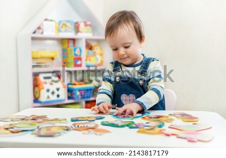 The child doing puzzle. Educational logic toys for kid's. Montessori Games for Child Development Royalty-Free Stock Photo #2143817179