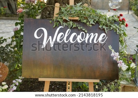 welcome sign at the entrance to a garden
