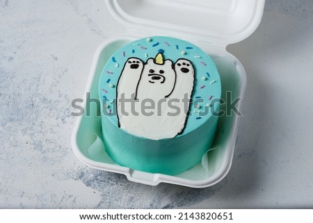 Bento cake for the holiday. A small cake with a picture or a congratulation for one person. A funny surprise dessert for a loved one. Cake with a teddy bear.