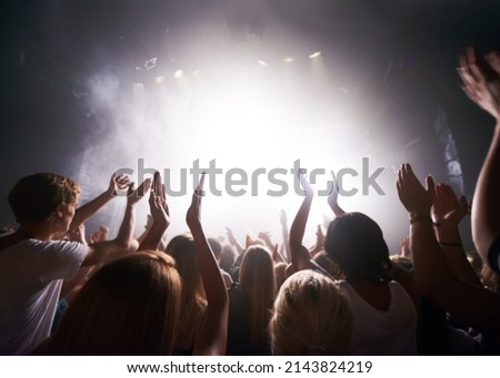 Satisfying their adoring fans. Rear-view of a crowd cheering at a concert- This concert was created for the sole purpose of this photo shoot, featuring 300 models and 3 live bands. All people in this Royalty-Free Stock Photo #2143824219