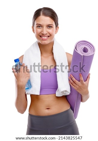 Keep calm and drink more water. Shot of a beautiful young woman holding an exercise mat and a bottle of water.