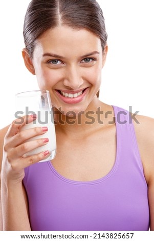 Keep calm and drink milk. Portrait of a beautiful woman holding a glass of milk.