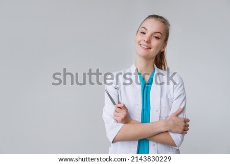 Young female dentist wearing in uniform with tweezers and mirror isolated on white Royalty-Free Stock Photo #2143830229