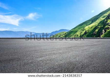 Empty asphalt road and green mountain nature landscape under blue sky. Road and mountains background. Royalty-Free Stock Photo #2143838357