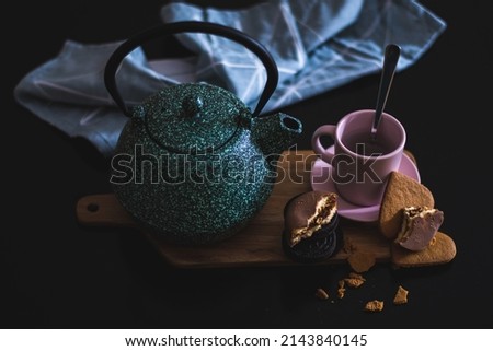 Valentines day healthy breakfast for couple with ceramic green teapot, chocolate cookies and heart shaped biscuit with a vintage look backery