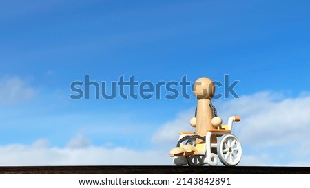 Wheelchair-riding doll and blue sky