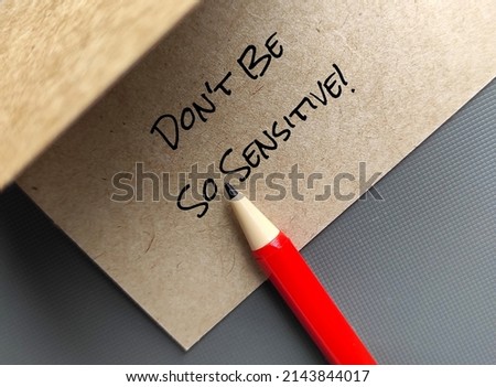 Red pen on handwriting craft paper card Don't Be So Sensitive, a gaslighting message to accuse or emotional abuse others to question their beliefs or doubt their perceptions and become distressed Royalty-Free Stock Photo #2143844017