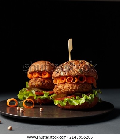 Healthy, delicious fast food. Vegan burger with vegetable or lentil cutlet, slices of vegetables. Low key, copy space.