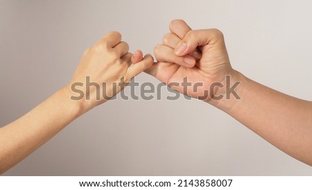 Man and woman do Pinky promise or pinky swear hands sign on white background. Royalty-Free Stock Photo #2143858007