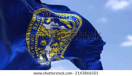 The US state flag of Nebraska waving in the wind. Nebraska is a state in the Midwestern region of the United States. Democracy and independence.