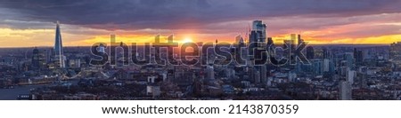 Wide panoramic view of the 2022 skyline of London during dusk from Westminster to the City with illuminated skyscrapers a colorful sky