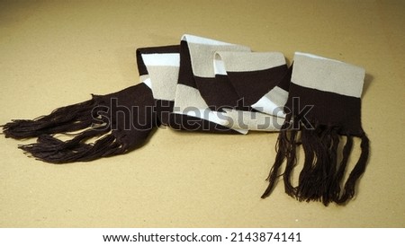 A woolen scarf with a brown and ivory color pattern                               