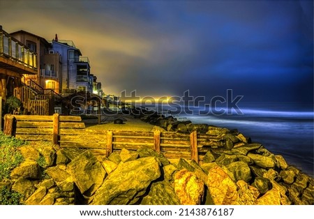 Houses on the coast in the late evening. Coastline city houses in evening time. Evening on coastline. Evening coastline landscape Royalty-Free Stock Photo #2143876187