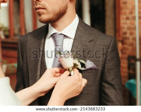 bride helps groom to wear a tie grain effect blond