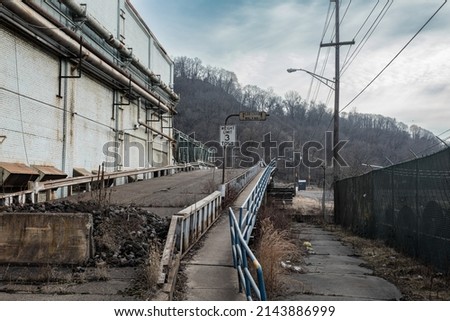 Abandoned bridge and walkway over train tracks in back of an industrial plant in a small midwest town