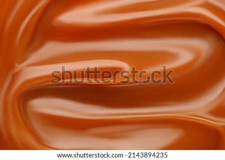 Liquid caramel syrup. Background of caramel paste. Curl of caramel. Texture Close up, top view. Cream Royalty-Free Stock Photo #2143894235