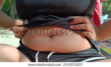 fat girl sitting on show body fat belly front. Royalty-Free Stock Photo #2143912057