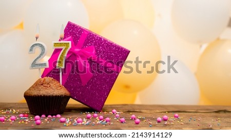 Happy birthday with a pink gift box for a 27 year old girl. Beautiful birthday card with a cupcake and a burning candle number twenty seven