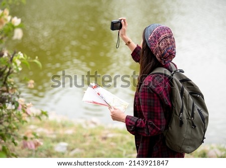 Beautiful Asian woman taking pictures in the park.