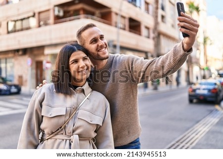 Man and woman couple smiling confident making selfie by the smartphone at street
