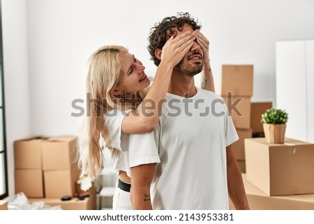 Woman surprising hes boyfriend covering eyes at new home. Royalty-Free Stock Photo #2143953381