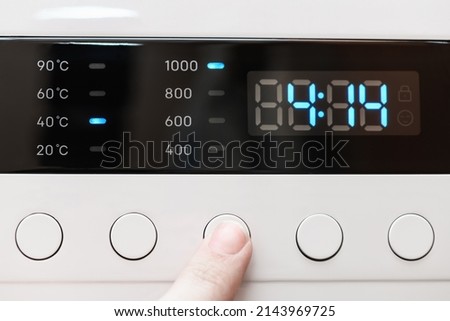 Washing machine display close up ,time remaining four hour 14 minutes during washing process. Finger selects wash mode. Abstract laundry programming backdrop Royalty-Free Stock Photo #2143969725