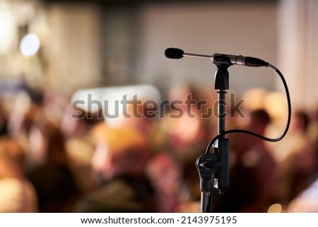 microphone on a blurred background. Microphone on abstract speech blur in seminar room or boardroom, event background. Royalty-Free Stock Photo #2143975195