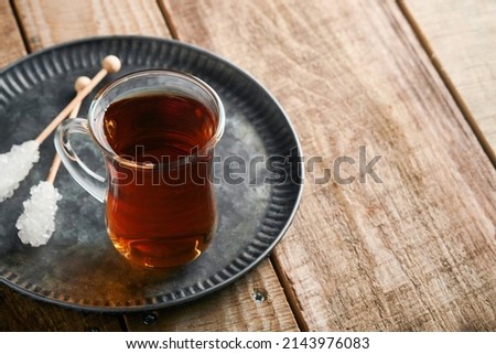 Turkish black tea. Glass cup of turkish black tea and crispy Turkish traditional bagel on old rustick background. Breakfast pastry concept. Traditional turkish brewed hot drink.