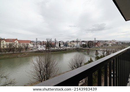 image of a city with a river and a bridge for people