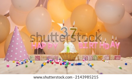 Beautiful background happy birthday number 37 with burning candles,birthday candles pink letters for thirty seven years. Festive background with balloons